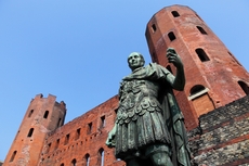Blick auf die römische Statue von Caesar Augustus vor den alten Ruinen der Palatine Türme in Turin